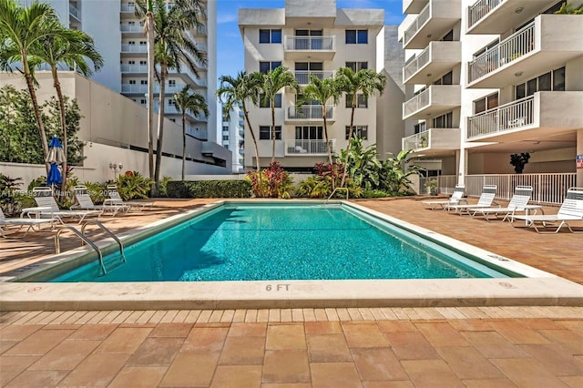 pool with a patio and fence