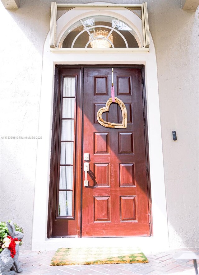 doorway to property featuring stucco siding