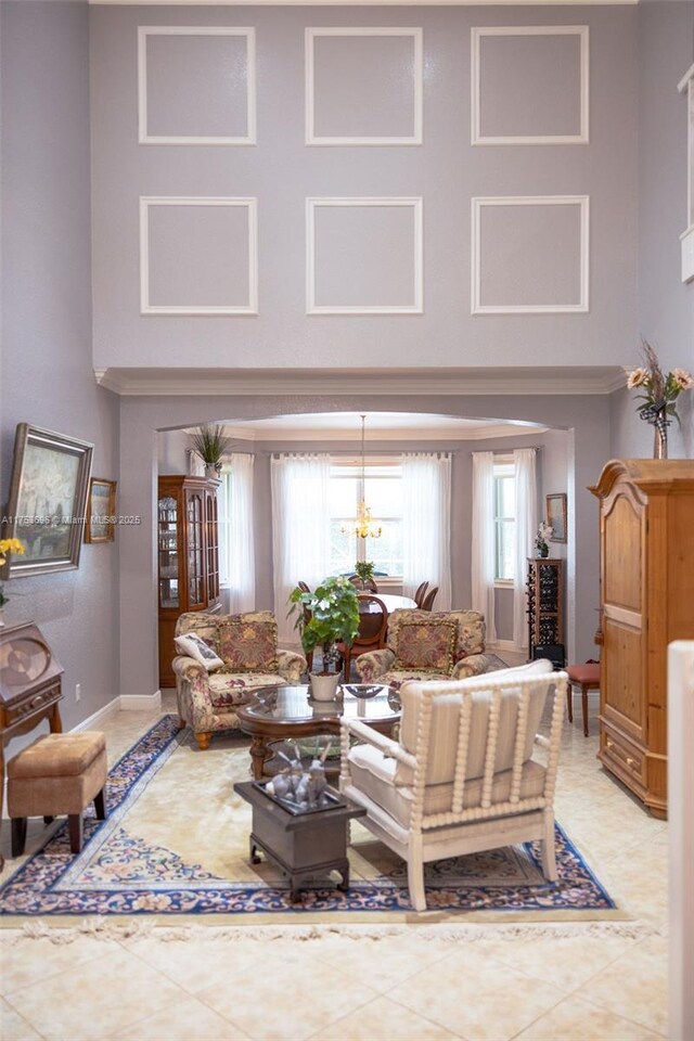 living room with light tile patterned floors, a high ceiling, and baseboards