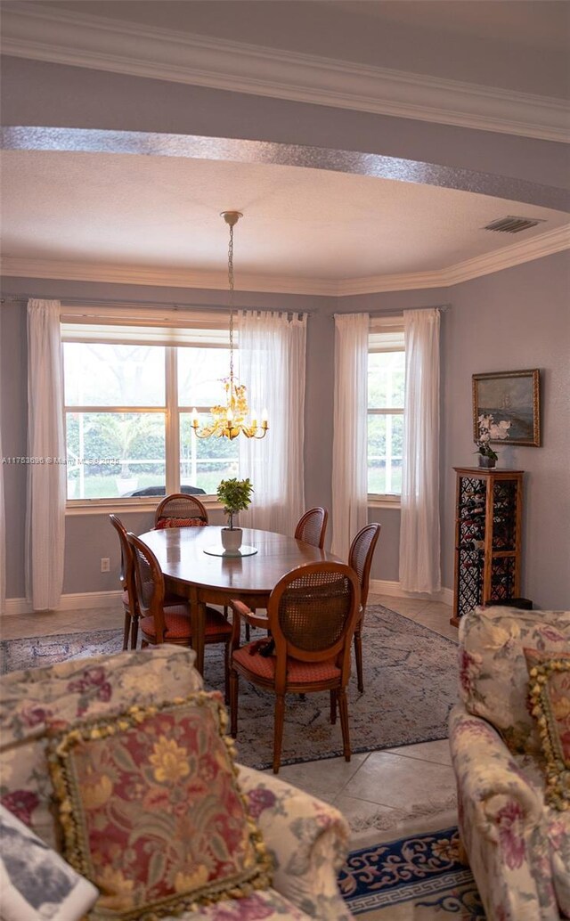 dining room with visible vents, ornamental molding, light tile patterned flooring, baseboards, and a chandelier