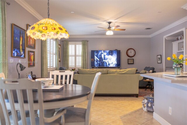 dining room with ceiling fan, visible vents, light tile patterned flooring, and crown molding