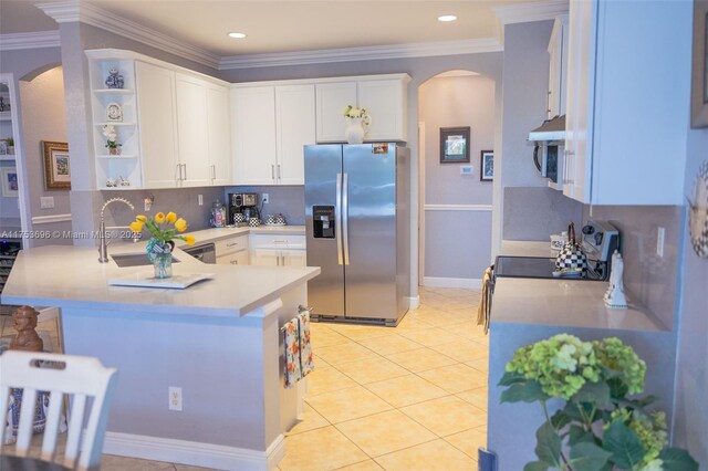 kitchen with a sink, a peninsula, arched walkways, stainless steel appliances, and open shelves