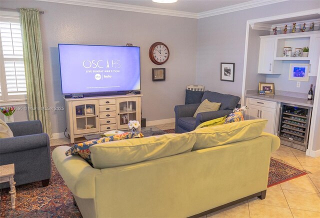 living area featuring light tile patterned floors, beverage cooler, baseboards, and ornamental molding