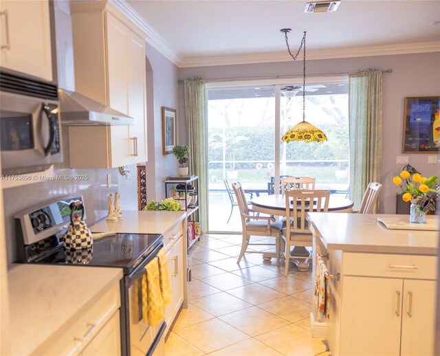 kitchen with stainless steel microwave, wall chimney range hood, range with electric stovetop, crown molding, and light countertops