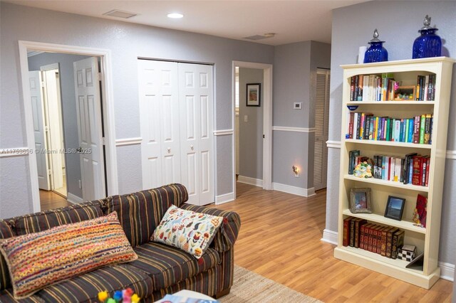 living area featuring recessed lighting, baseboards, and wood finished floors