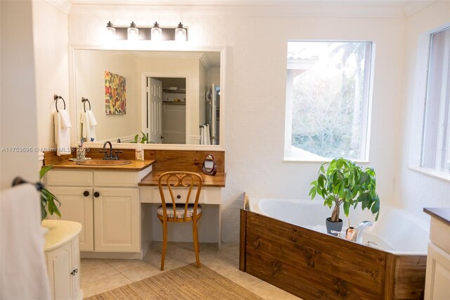 bathroom featuring tile patterned flooring, crown molding, a bath, and vanity