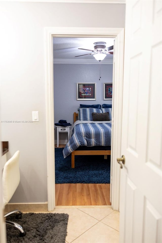 bedroom featuring tile patterned flooring, a ceiling fan, and ornamental molding