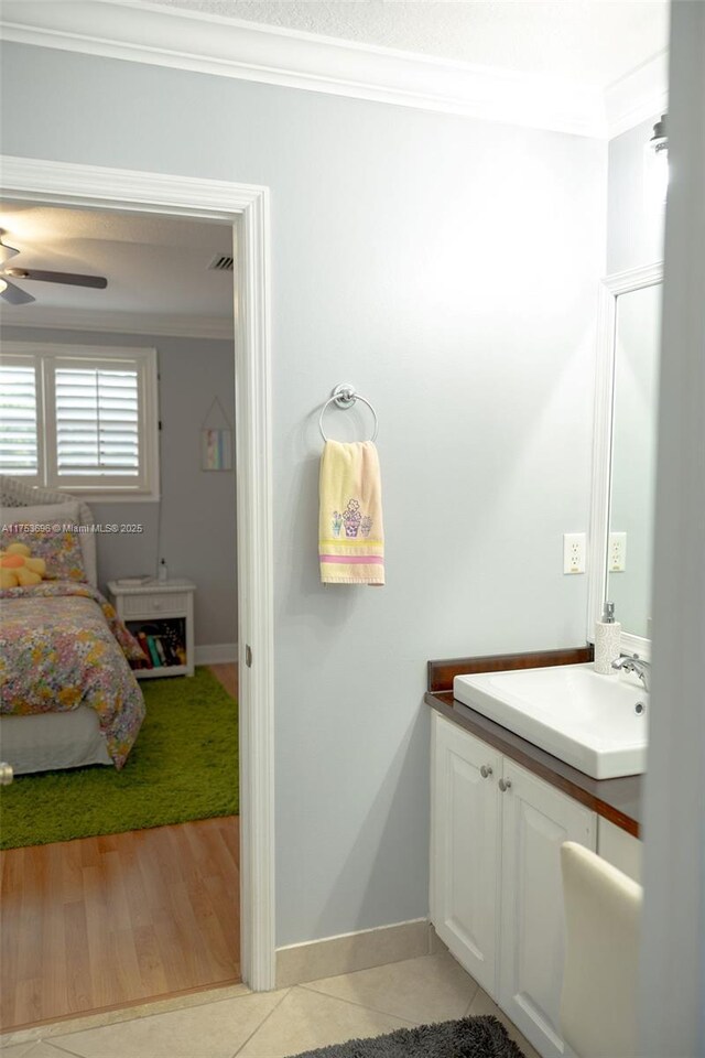 bathroom featuring tile patterned floors, baseboards, a ceiling fan, and ornamental molding