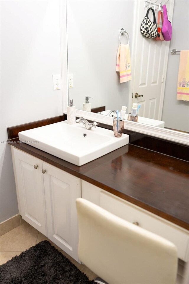 bathroom featuring tile patterned floors, baseboards, and vanity