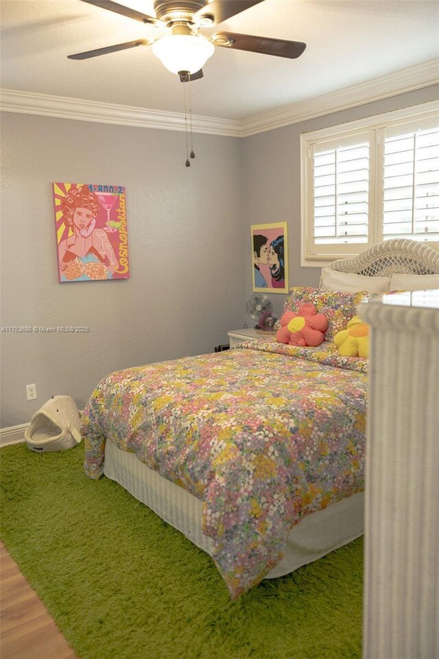 bedroom featuring ceiling fan, wood finished floors, and ornamental molding