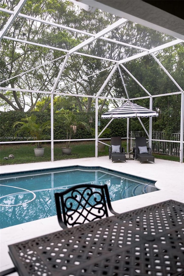 pool with a patio, fence, and a lanai