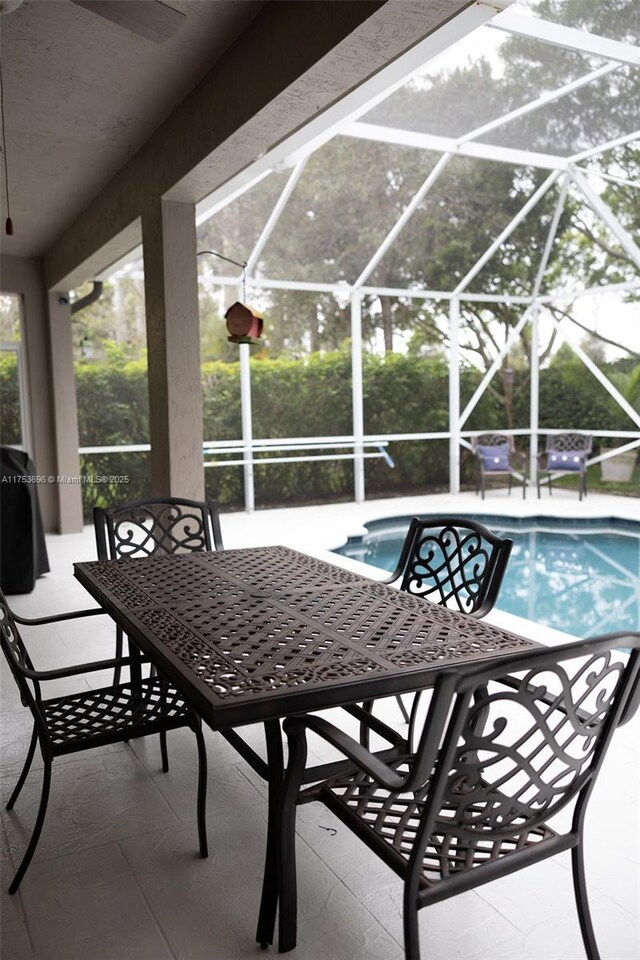 exterior space with glass enclosure, outdoor dining area, and a patio area