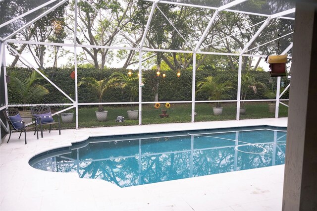 outdoor pool with a lanai and a patio area