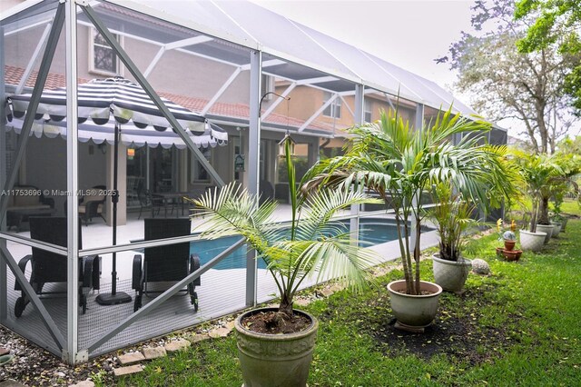 outdoor pool featuring glass enclosure and a patio