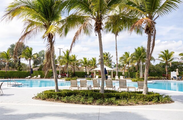 community pool with a gazebo and a patio