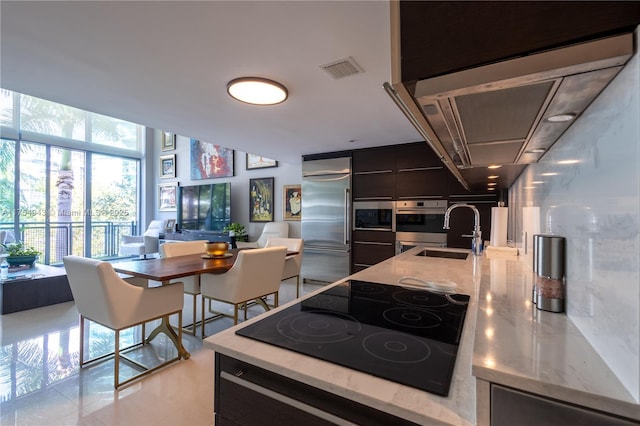 kitchen with visible vents, appliances with stainless steel finishes, open floor plan, a sink, and modern cabinets