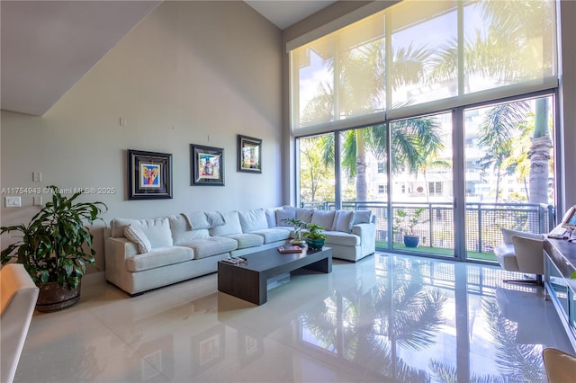 tiled living room featuring floor to ceiling windows and high vaulted ceiling