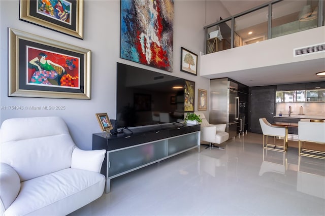 living room featuring a high ceiling and visible vents