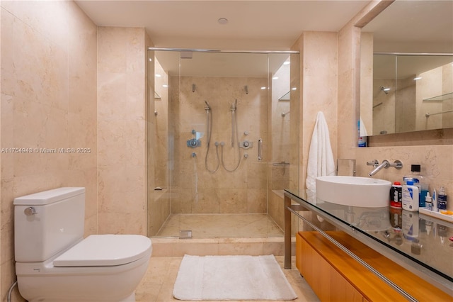 full bath with a stall shower, toilet, tile walls, and vanity