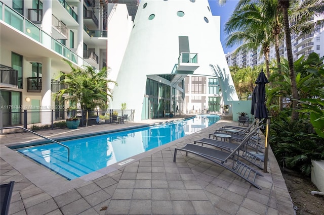 pool featuring fence and a patio