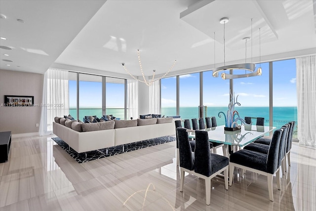 dining area with expansive windows and a water view