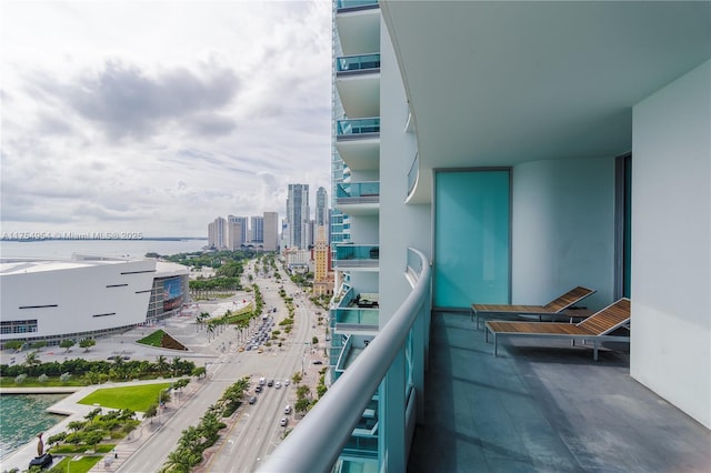 balcony featuring a water view and a city view