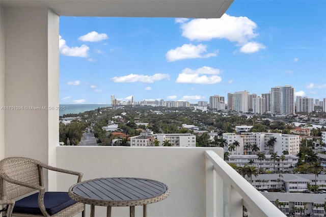 balcony featuring a water view and a city view