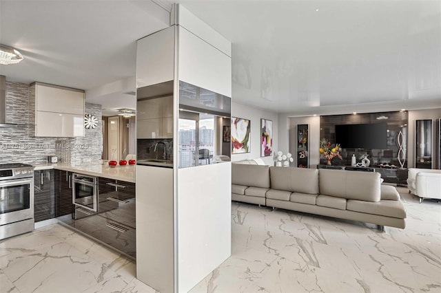 kitchen featuring stainless steel range with gas cooktop, marble finish floor, light countertops, and modern cabinets