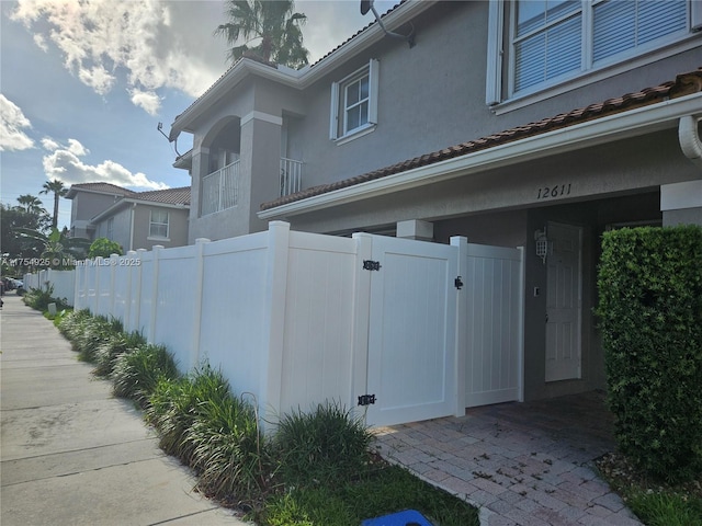 view of home's exterior with a fenced front yard, a gate, and stucco siding