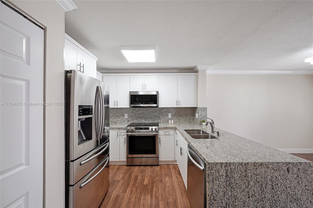 12611 SW 54th Ct Unit 12611, Miramar, FL 33027 - kitchen with stainless steel appliances, dark wood-type flooring, light stone counters, white cabinets, and ornamental molding