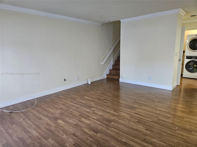 spare room with crown molding, stairway, wood finished floors, and stacked washer / drying machine