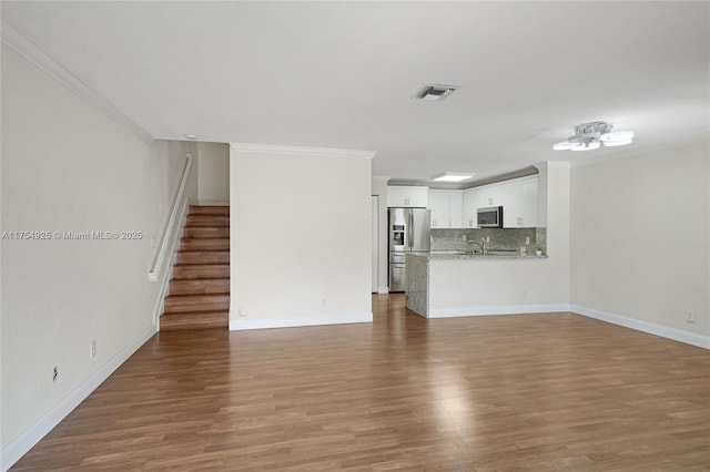 12611 SW 54th Ct Unit 12611, Miramar, FL 33027 - unfurnished living room with crown molding, stairs, and wood finished floors