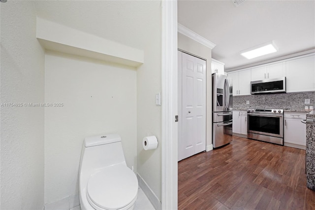 12611 SW 54th Ct Unit 12611, Miramar, FL 33027 - kitchen with stainless steel appliances, white cabinets, decorative backsplash, dark wood-type flooring, and ornamental molding