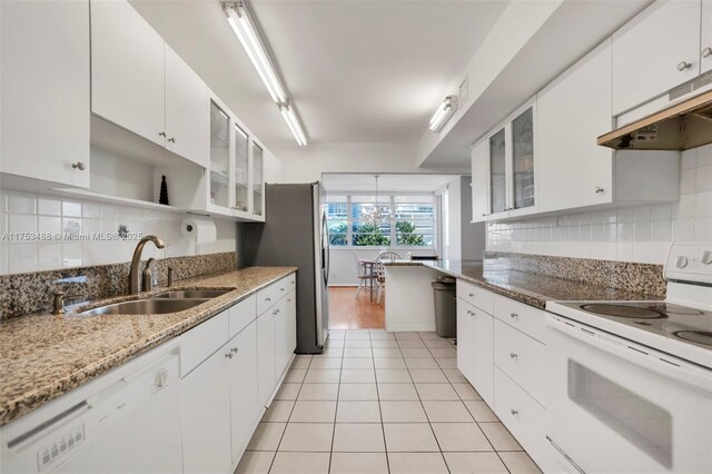 kitchen featuring tasteful backsplash, white appliances, and white cabinetry