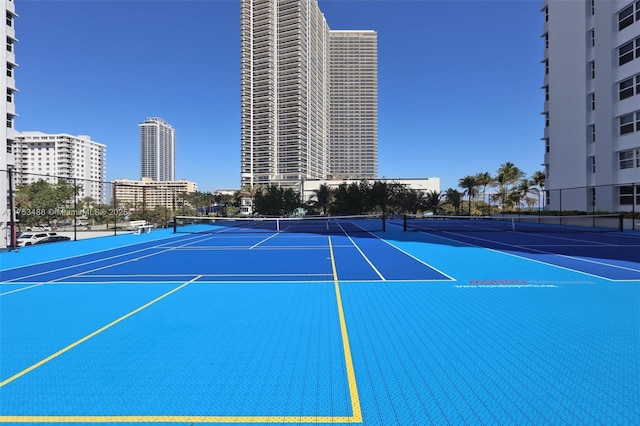 view of sport court featuring a city view, community basketball court, and fence