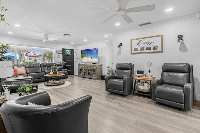 living room with light wood finished floors, ceiling fan, visible vents, and ornamental molding