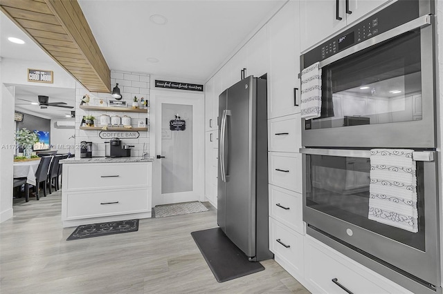 kitchen with ceiling fan, appliances with stainless steel finishes, light wood-type flooring, white cabinetry, and open shelves