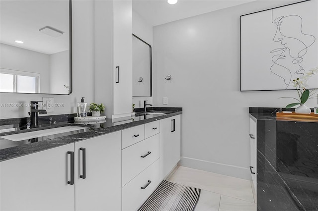 bathroom with recessed lighting, a sink, baseboards, and double vanity