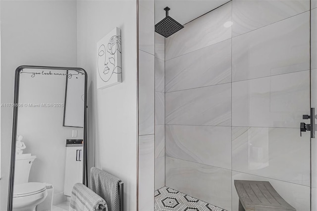 bathroom featuring radiator, toilet, and tiled shower