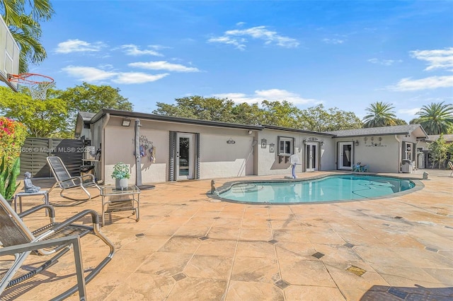 back of property with a patio area, an outdoor pool, and stucco siding