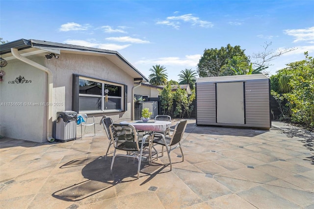 view of patio featuring outdoor dining space, a shed, and an outdoor structure