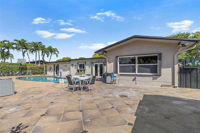 back of house featuring a fenced in pool, french doors, stucco siding, a patio area, and fence