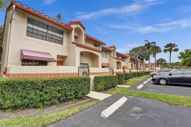 view of property featuring uncovered parking, fence, and a residential view