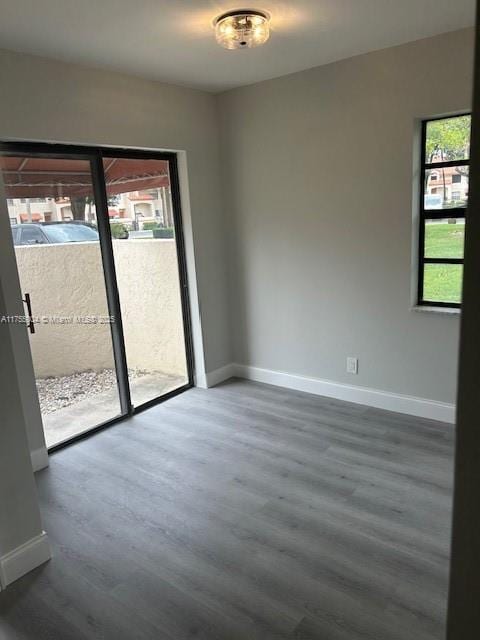 empty room with dark wood finished floors and baseboards