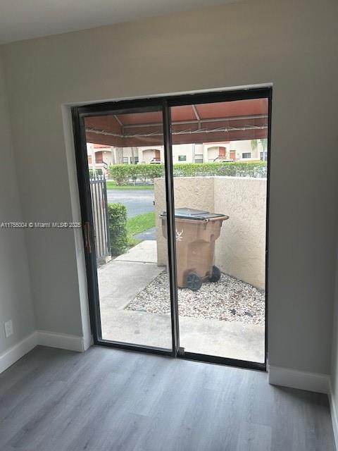 entryway with wood finished floors and baseboards