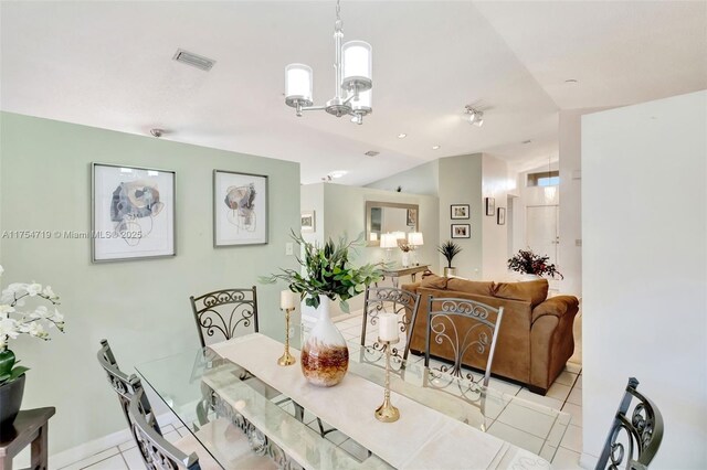 dining space with lofted ceiling, visible vents, an inviting chandelier, and light tile patterned floors