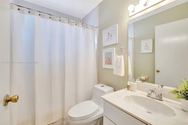 bathroom featuring curtained shower, vanity, and toilet