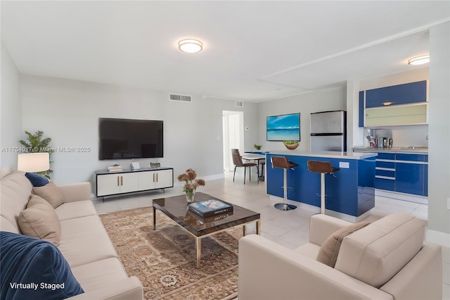 living area featuring visible vents and light tile patterned flooring