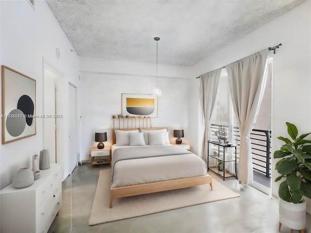 bedroom featuring concrete flooring, access to exterior, and a textured ceiling