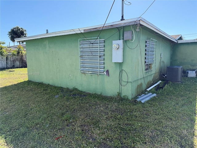 view of side of property featuring central air condition unit, a yard, and fence